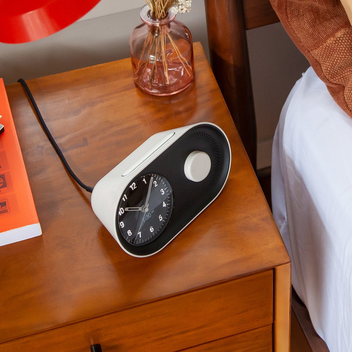 Arc Alarm Clock in white on a bedside table 